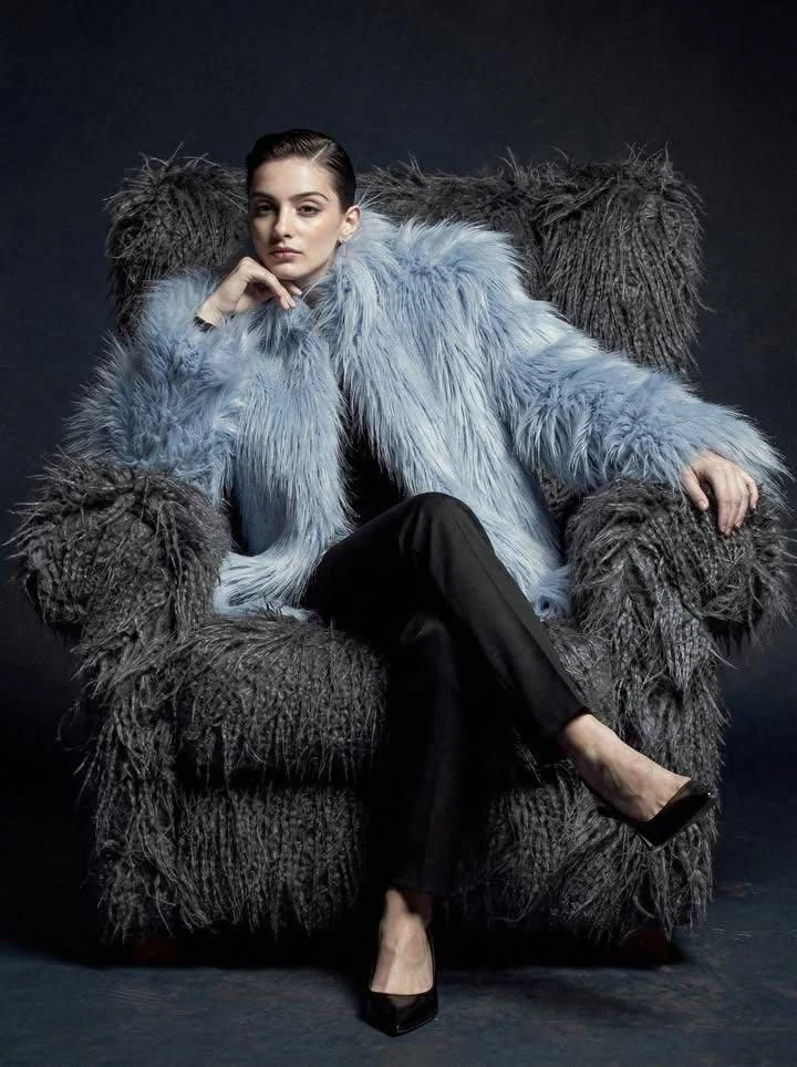 Ultra-high fashion editorial portrait of a confident female model seated...