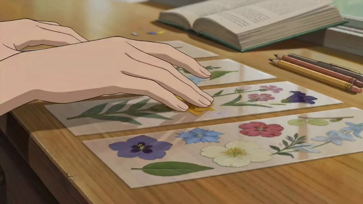 ASMR anime scene of hands creating a pressed-flower bookmark on a warm wo...