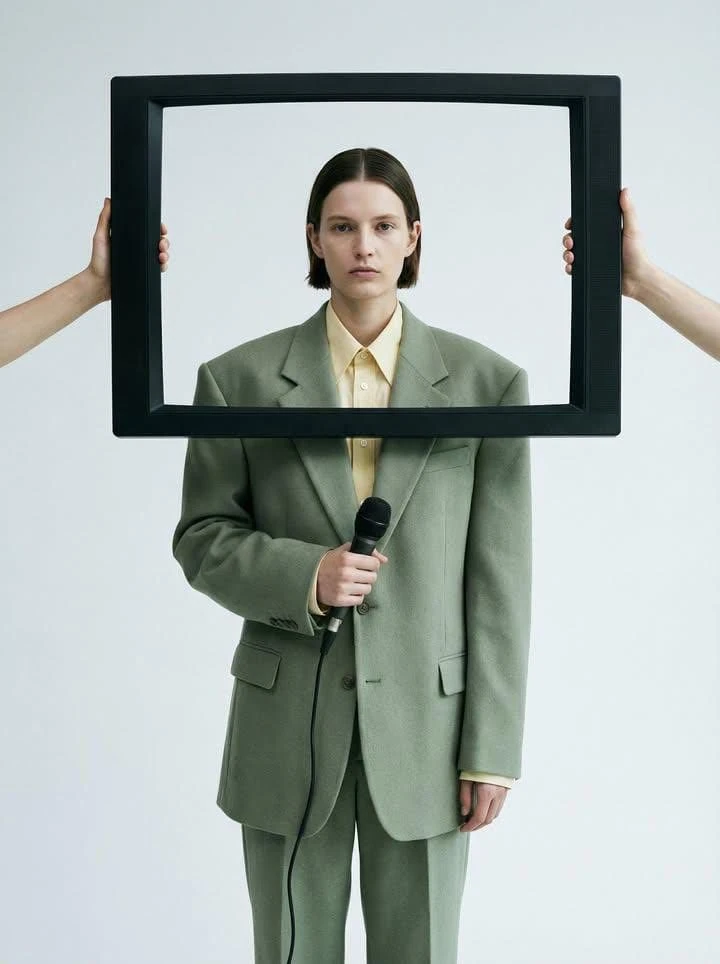 Minimalist conceptual fashion portrait of an androgynous model wearing an...