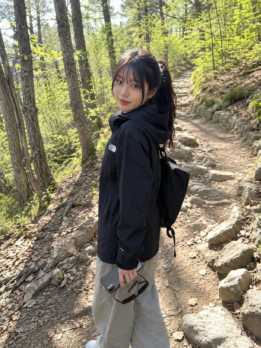 Young Japanese woman on a casual hiking trip, standing on a rugged forest...