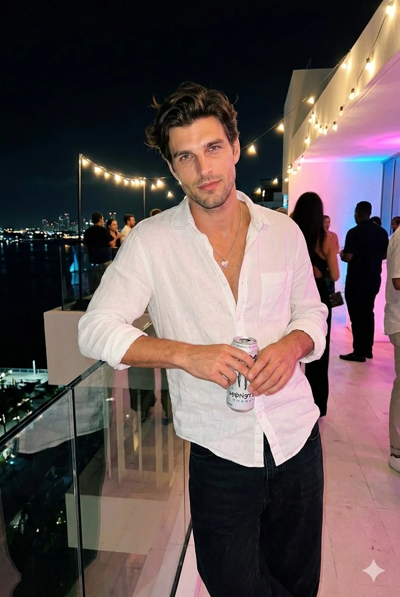 Nighttime roof-terrace party photo. Subject relaxed, slight side profile...
