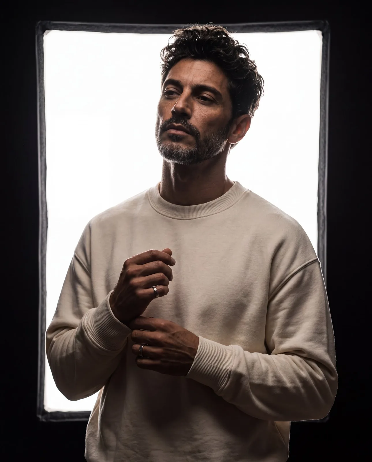 Scene: a dark studio space with a huge glowing rectangular softbox or whi...
