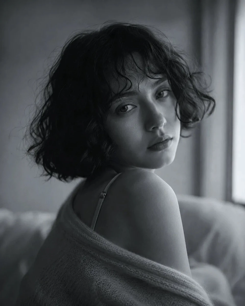 Ethereal fine-art black and white portrait of a young woman with a short...