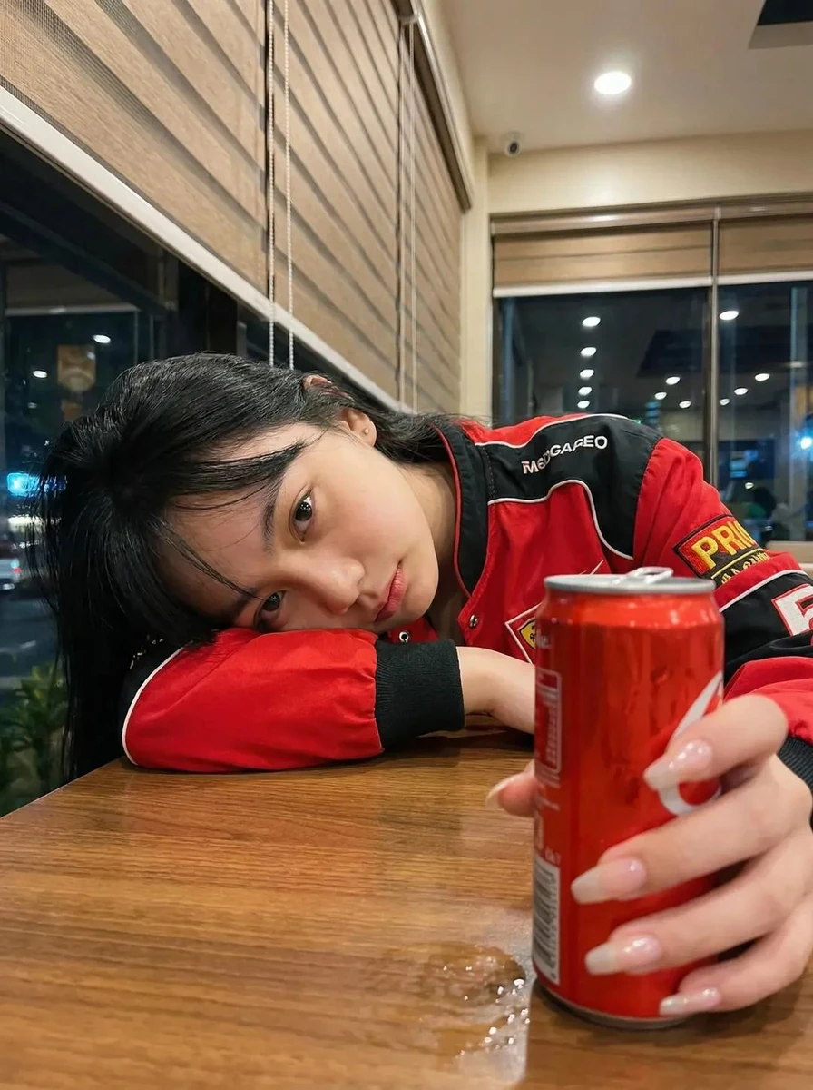 Ultra-realistic photo of a young woman sitting in a cozy café at night, r...