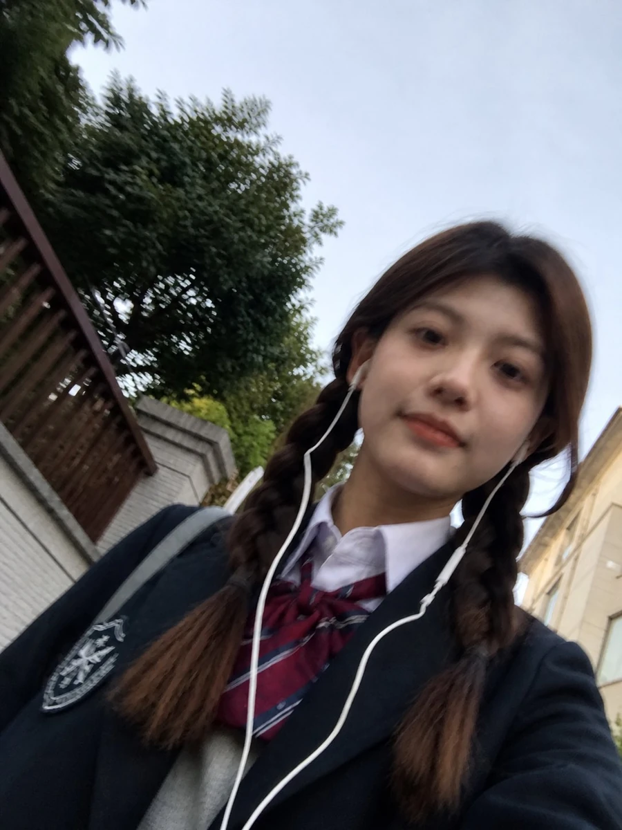 A rough phone-photo selfie of a person, with slight motion blur on the fa...