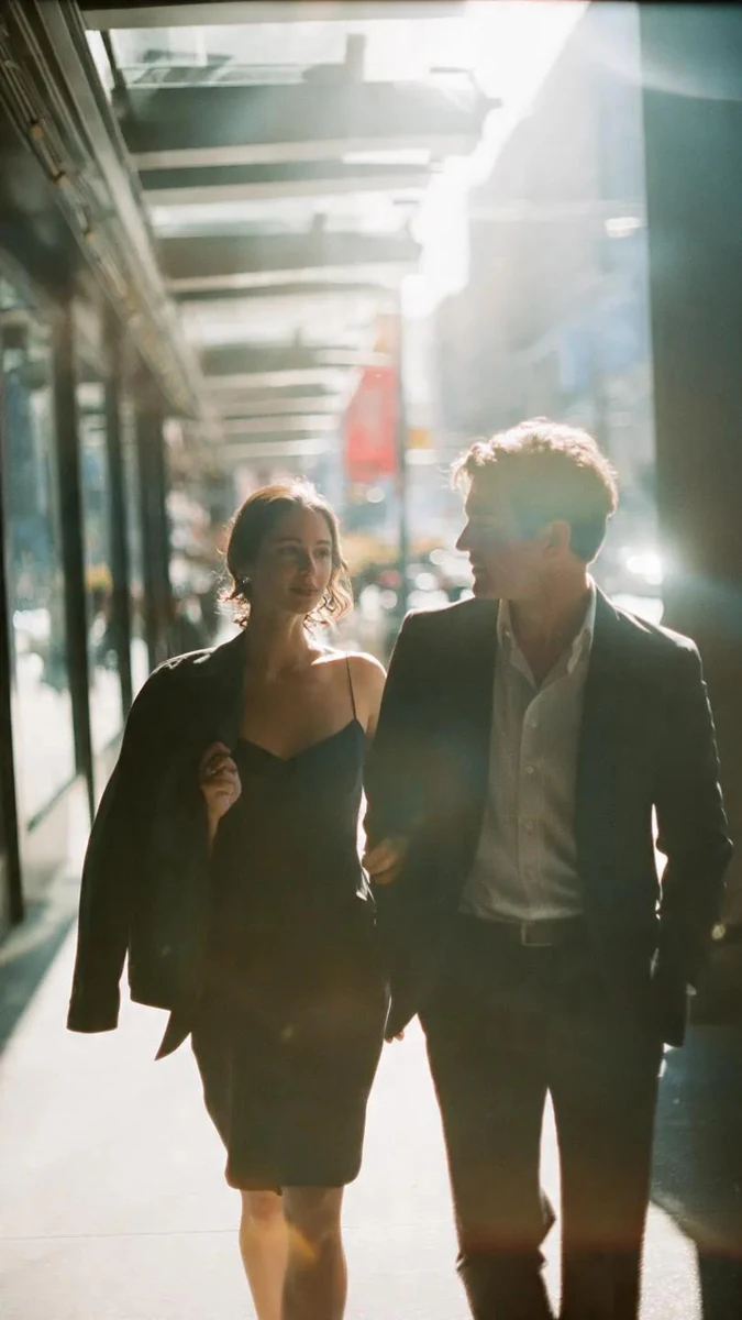 A cinematic candid medium shot portrait of a man and a woman walking side...