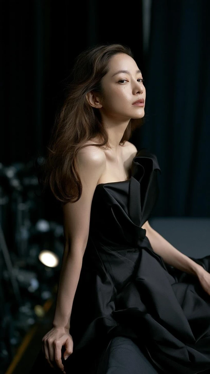 A visually young and elegant woman, skin firm and luminous with a dewy gl...